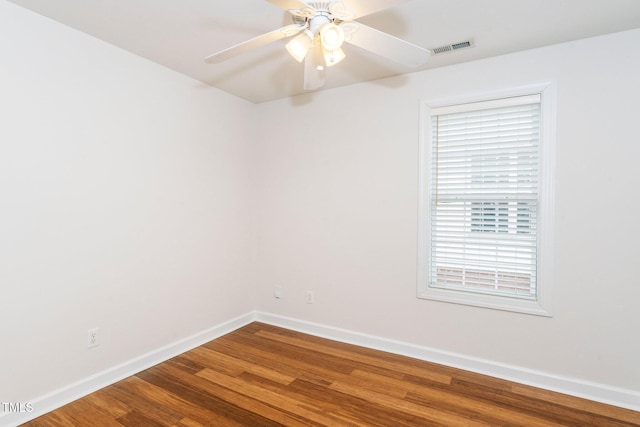 empty room featuring visible vents, ceiling fan, baseboards, and wood finished floors