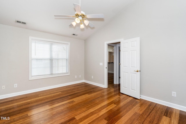 empty room featuring vaulted ceiling, wood finished floors, visible vents, and baseboards