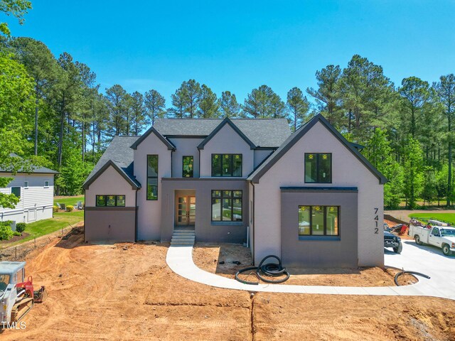 7412 Wexford Woods Ln, Wake Forest, NC 27587 - modern inspired farmhouse featuring a shingled roof, stucco siding, and french doors