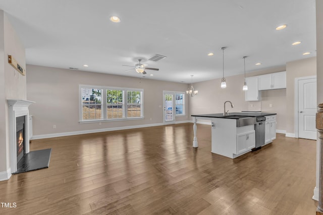 kitchen with open floor plan, a lit fireplace, dark countertops, and visible vents