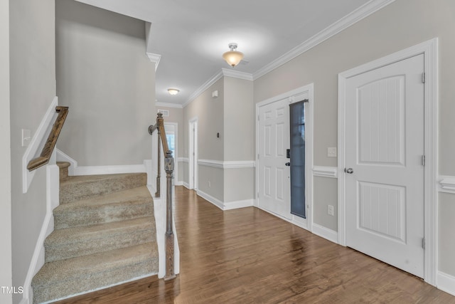 entrance foyer featuring crown molding, stairway, baseboards, and wood finished floors