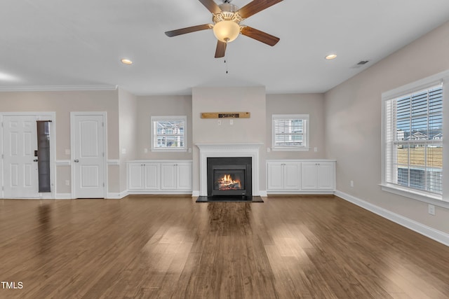 unfurnished living room featuring a healthy amount of sunlight, baseboards, and wood finished floors