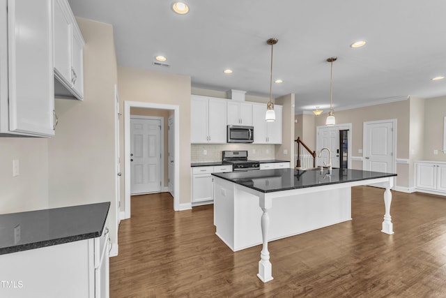 kitchen with stainless steel appliances, dark wood-style flooring, white cabinets, and visible vents