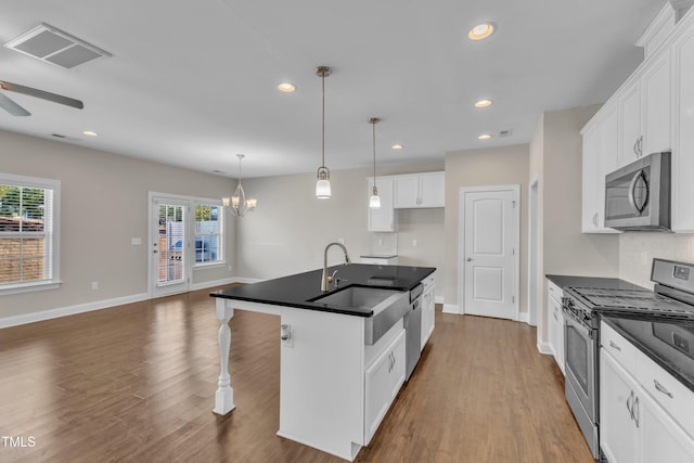 kitchen featuring dark countertops, visible vents, stainless steel appliances, and a sink