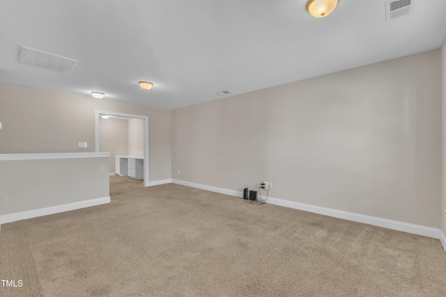 unfurnished room with light colored carpet, visible vents, and baseboards