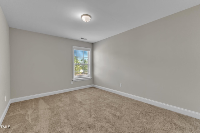 carpeted empty room featuring visible vents and baseboards