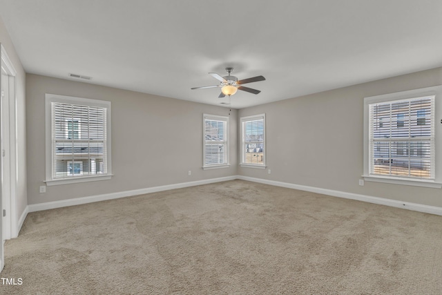 empty room with baseboards, visible vents, and carpet flooring