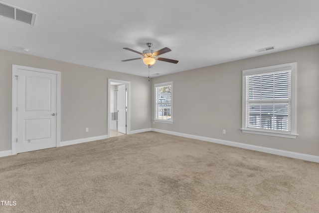 empty room with visible vents, light carpet, and baseboards