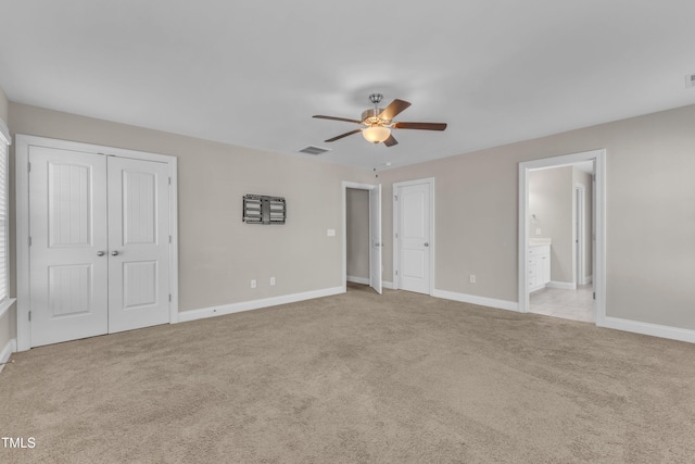 unfurnished bedroom with carpet floors, baseboards, visible vents, and connected bathroom