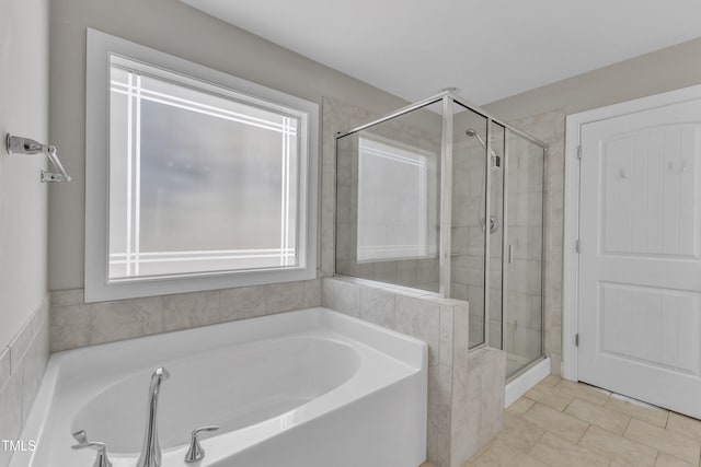 bathroom featuring a stall shower, tile patterned flooring, and a garden tub