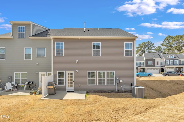 rear view of property featuring cooling unit, a patio area, and a yard