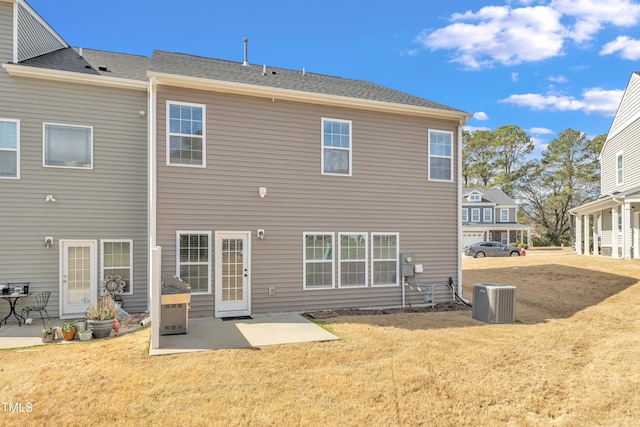 rear view of house featuring central air condition unit, a patio area, and a lawn