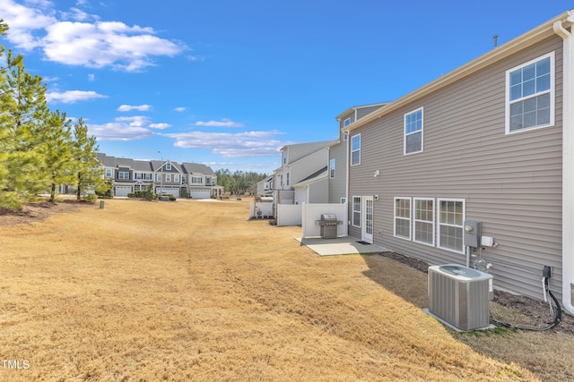 exterior space featuring a residential view, cooling unit, and a patio