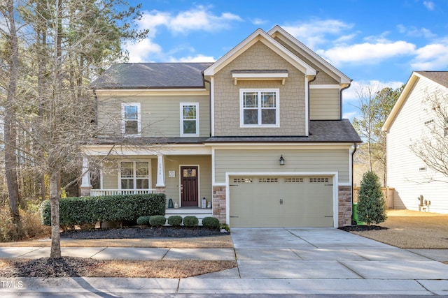 craftsman-style home with a porch, stone siding, driveway, and an attached garage