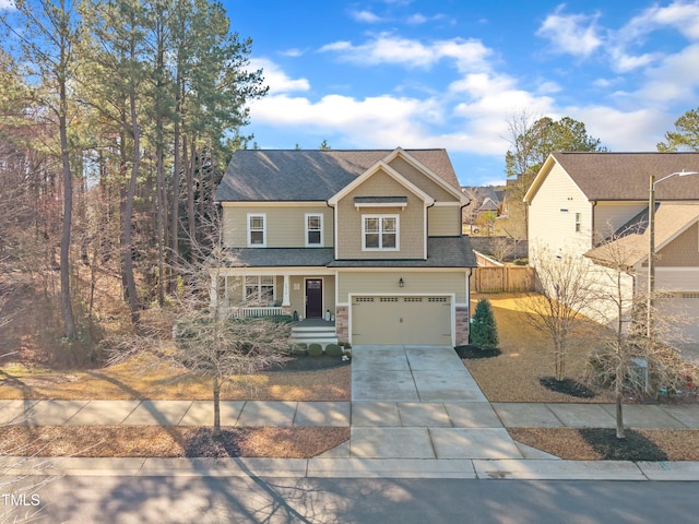 view of front of home with driveway, stone siding, a garage, and fence