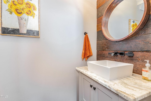 bathroom with vanity and wood walls