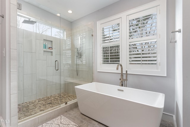 bathroom featuring shower with separate bathtub