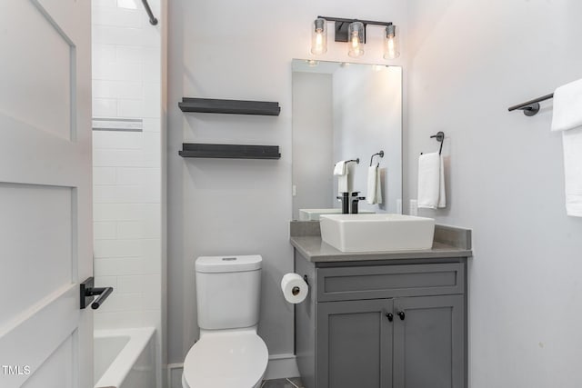 full bathroom with vanity, tiled shower / bath combo, and toilet