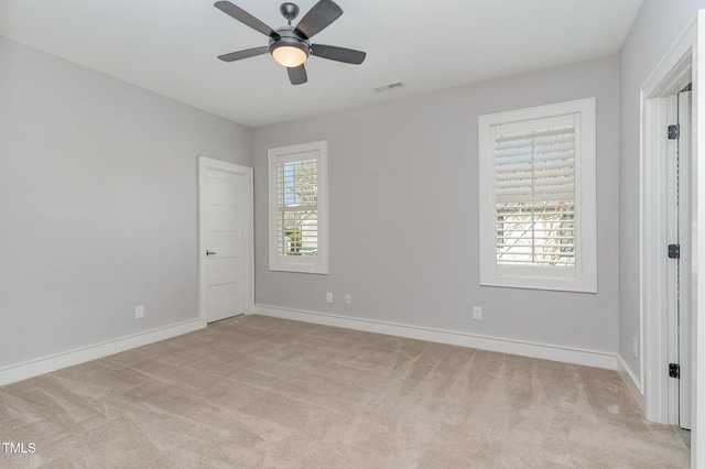 carpeted empty room featuring plenty of natural light and ceiling fan