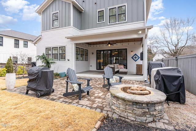 back of property with a patio area, ceiling fan, and an outdoor fire pit