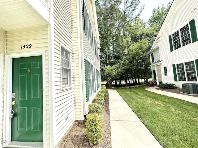 exterior space featuring central AC unit and a lawn