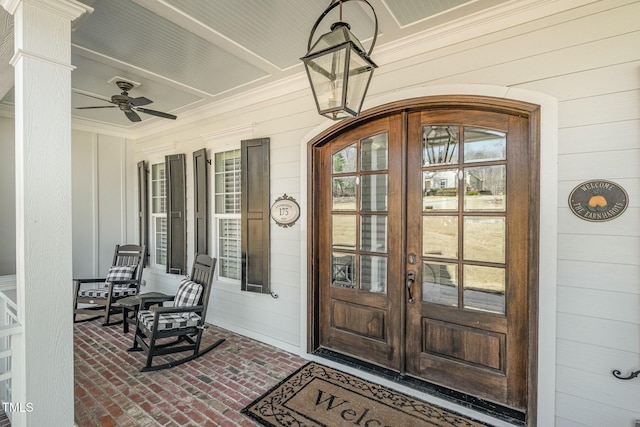 entrance to property with ceiling fan, a porch, and french doors