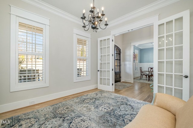 interior space with crown molding, a healthy amount of sunlight, hardwood / wood-style floors, and french doors