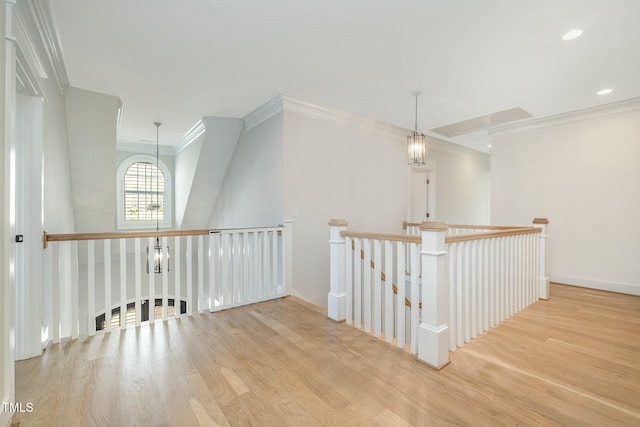 corridor featuring a notable chandelier, recessed lighting, wood finished floors, an upstairs landing, and crown molding