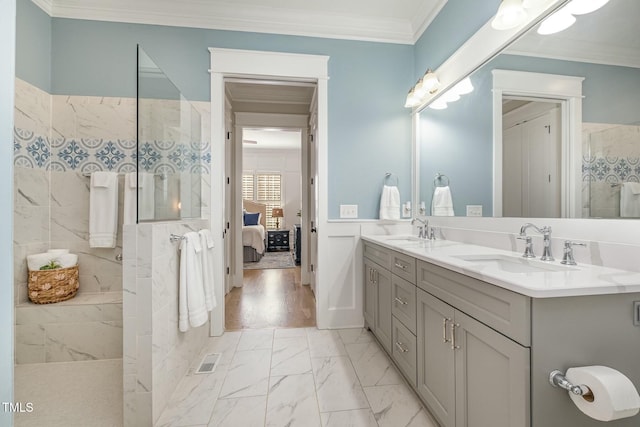 ensuite bathroom featuring ornamental molding, marble finish floor, a sink, and ensuite bathroom