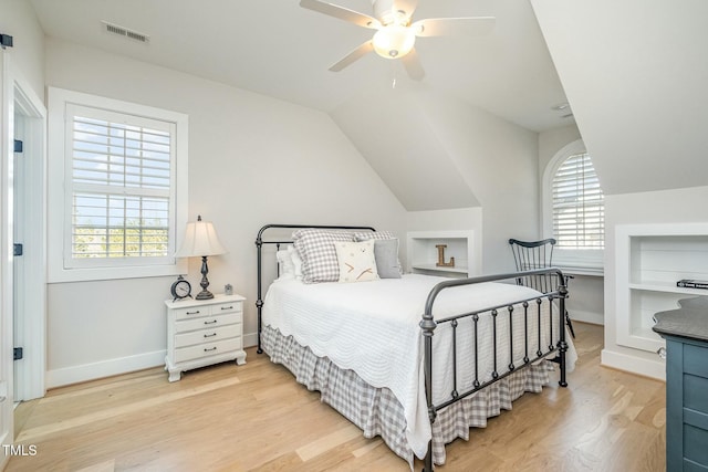 bedroom with multiple windows, vaulted ceiling, ceiling fan, and light wood-type flooring