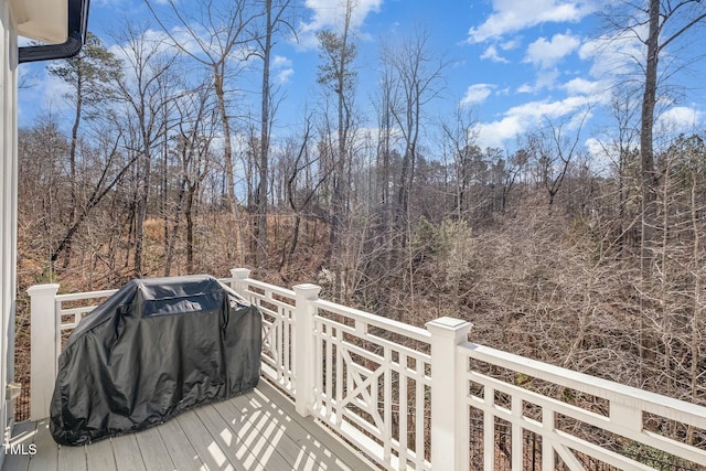 wooden deck with a grill and a view of trees