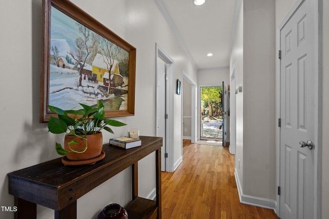 corridor with crown molding and light hardwood / wood-style flooring