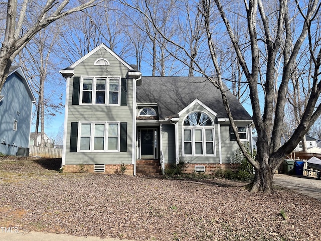 traditional home with entry steps, a shingled roof, and crawl space