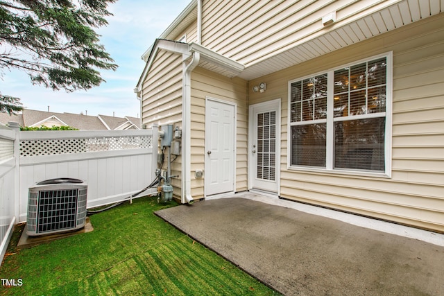 property entrance with a yard, a patio area, and central air condition unit