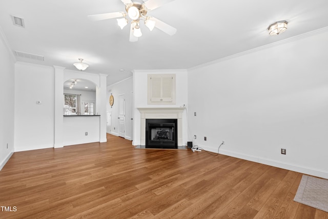 unfurnished living room with ceiling fan, wood-type flooring, and ornamental molding