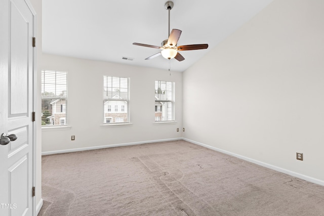 empty room featuring light carpet, vaulted ceiling, and ceiling fan