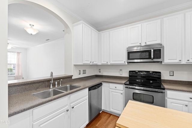 kitchen featuring sink, white cabinetry, ornamental molding, stainless steel appliances, and light hardwood / wood-style floors