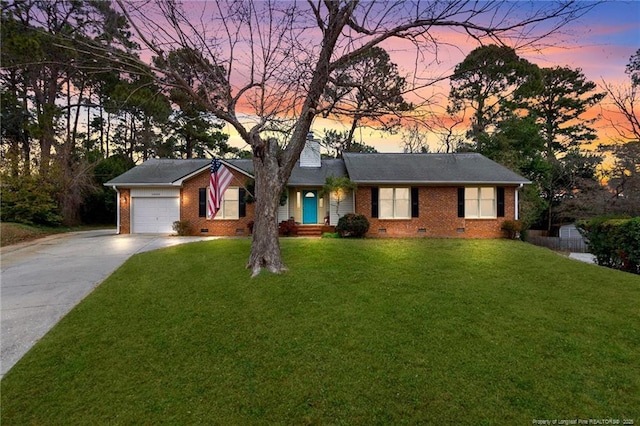 ranch-style home featuring a yard and a garage