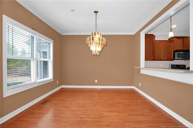 unfurnished dining area with ornamental molding, light hardwood / wood-style floors, and a notable chandelier