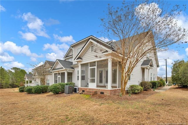 view of front of property featuring french doors, a front yard, a sunroom, crawl space, and central AC unit