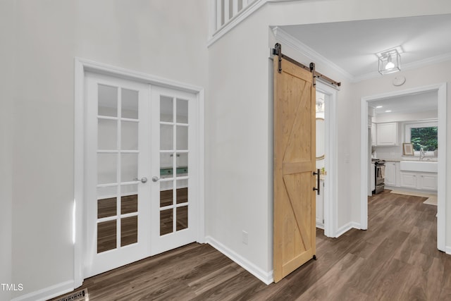 100 Windvale Ct, Cary, NC 27518 - corridor featuring a barn door, dark wood-type flooring, ornamental molding, baseboards, and french doors