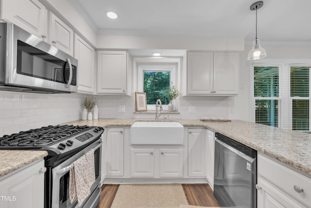 100 Windvale Ct, Cary, NC 27518 - kitchen with appliances with stainless steel finishes, a sink, ornamental molding, white cabinets, and light wood-type flooring