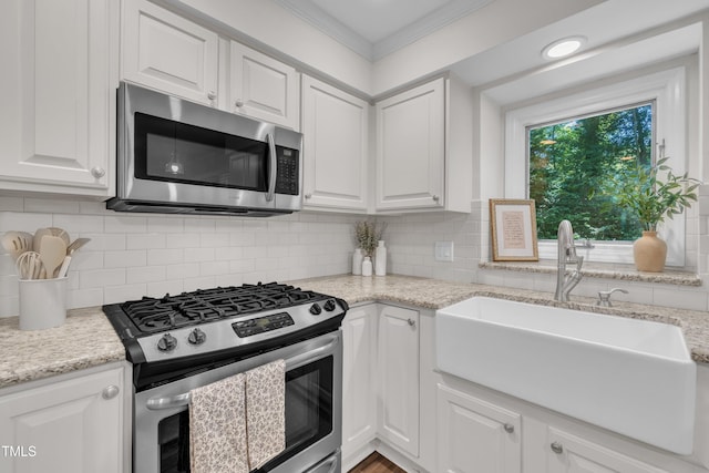 100 Windvale Ct, Cary, NC 27518 - kitchen with appliances with stainless steel finishes, white cabinets, backsplash, crown molding, and light stone countertops