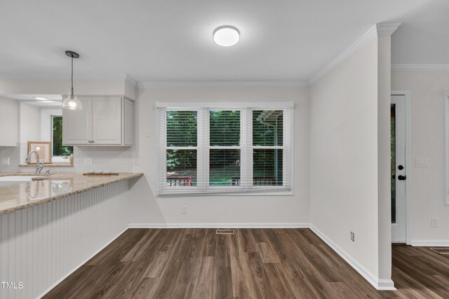 100 Windvale Ct, Cary, NC 27518 - unfurnished dining area featuring a sink, dark wood-style floors, healthy amount of natural light, crown molding, and baseboards