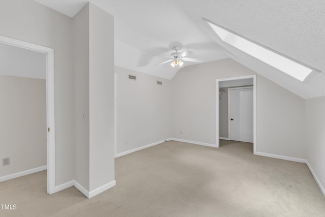 100 Windvale Ct, Cary, NC 27518 - bonus room with a skylight, vaulted ceiling, light carpet, and ceiling fan