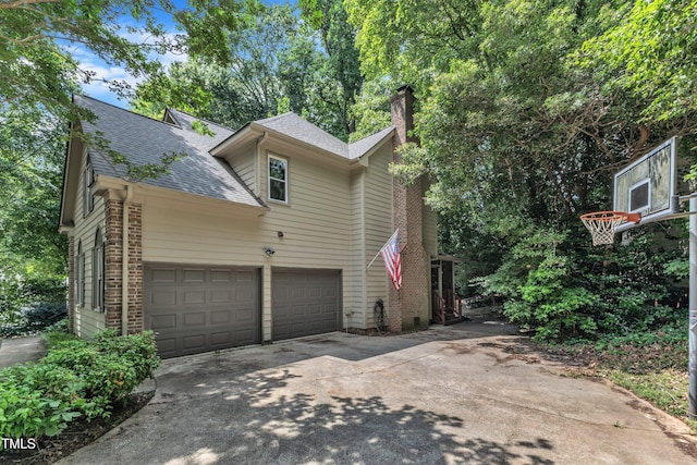 100 Windvale Ct, Cary, NC 27518 - view of side of home with concrete driveway, a chimney, brick siding, and a shingled roof