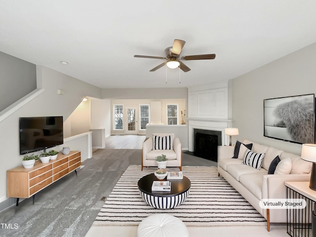 living room featuring hardwood / wood-style flooring, a large fireplace, and ceiling fan