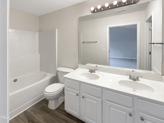 full bathroom with bathing tub / shower combination, toilet, vanity, and wood-type flooring