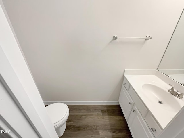 bathroom with hardwood / wood-style flooring, vanity, and toilet