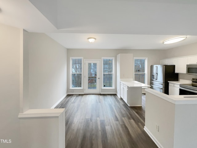 kitchen featuring appliances with stainless steel finishes, kitchen peninsula, dark hardwood / wood-style floors, and white cabinets